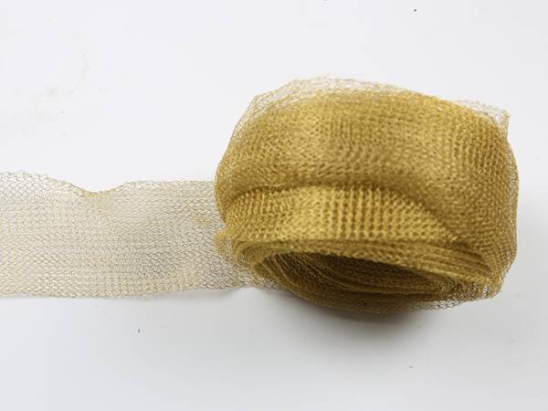 A roll of brass shielding mesh on gray background.