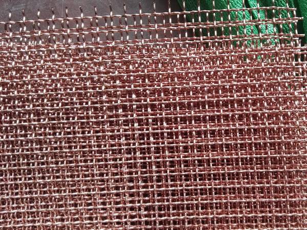 Several pieces o f intermediate weave copper crimped mesh.