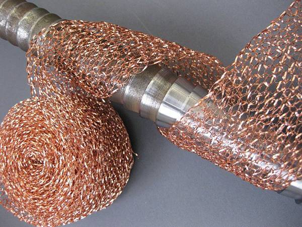 A roll of knitted copper mesh is twisting a mechanical part.