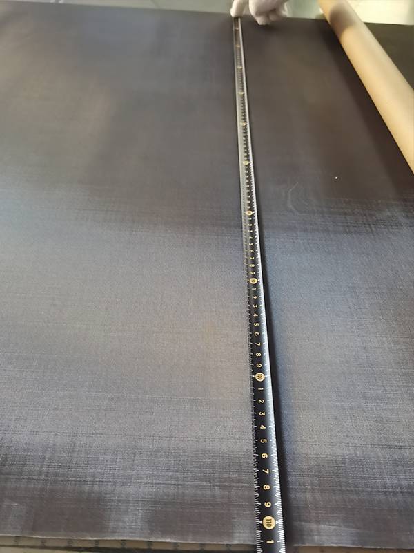 A ruler is used to check the width of blackened copper wire mesh.
