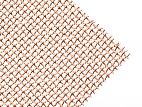 A piece of plain weave coarse copper mesh on white background.