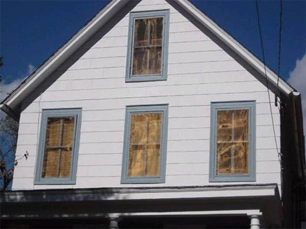 Four windows of houses are covered with copper insect screens.