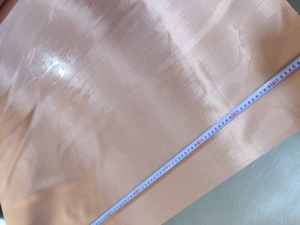 Measure the width of a copper wire mesh on a workbench