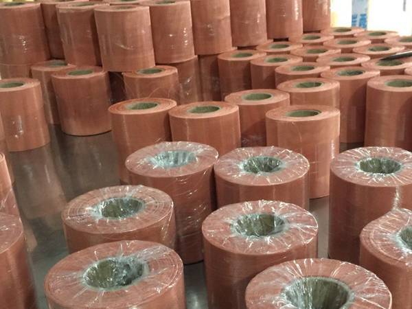 Several small rolls of copper woven meshes on the table.