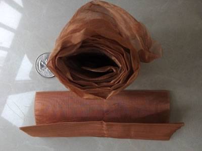 Two rolls folded copper mesh: one is standing and the other is lying on the ground.