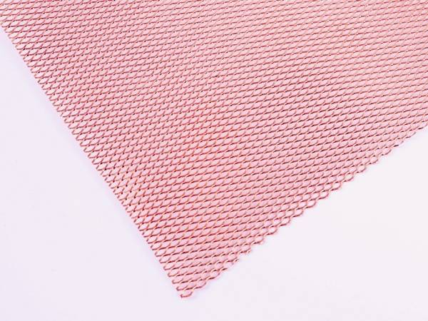 A roll of knitted copper wire mesh on gray background.