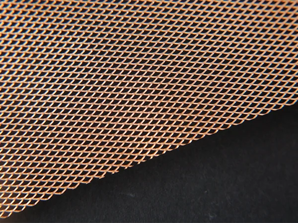 A roll of knitted copper wire mesh on black background